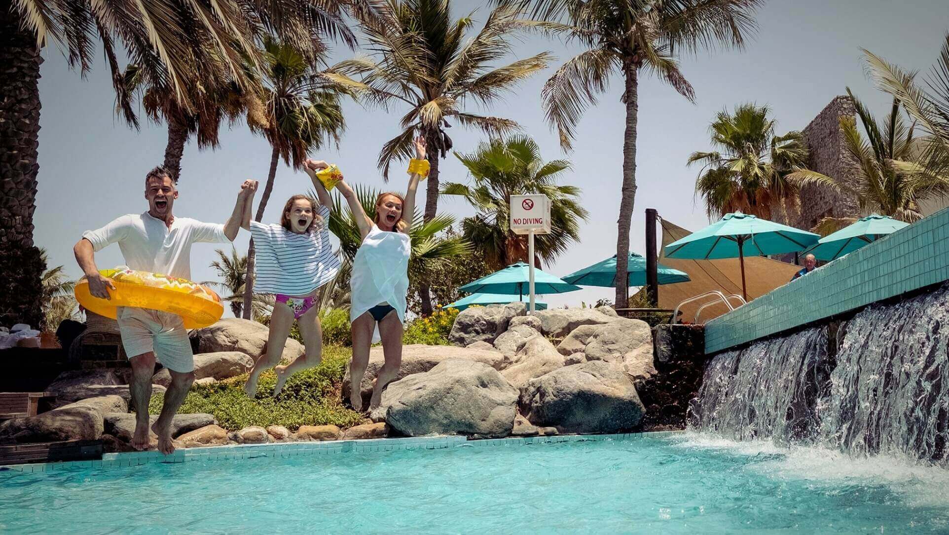 Family Jumping In Pool