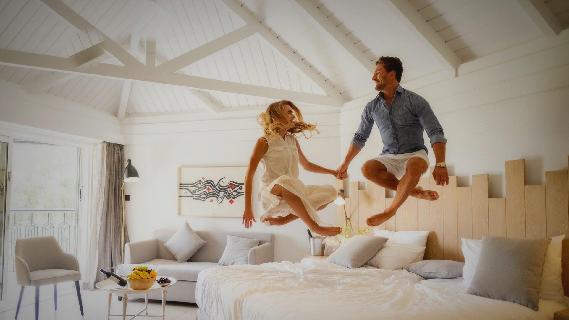Couple Jumping on King Bed