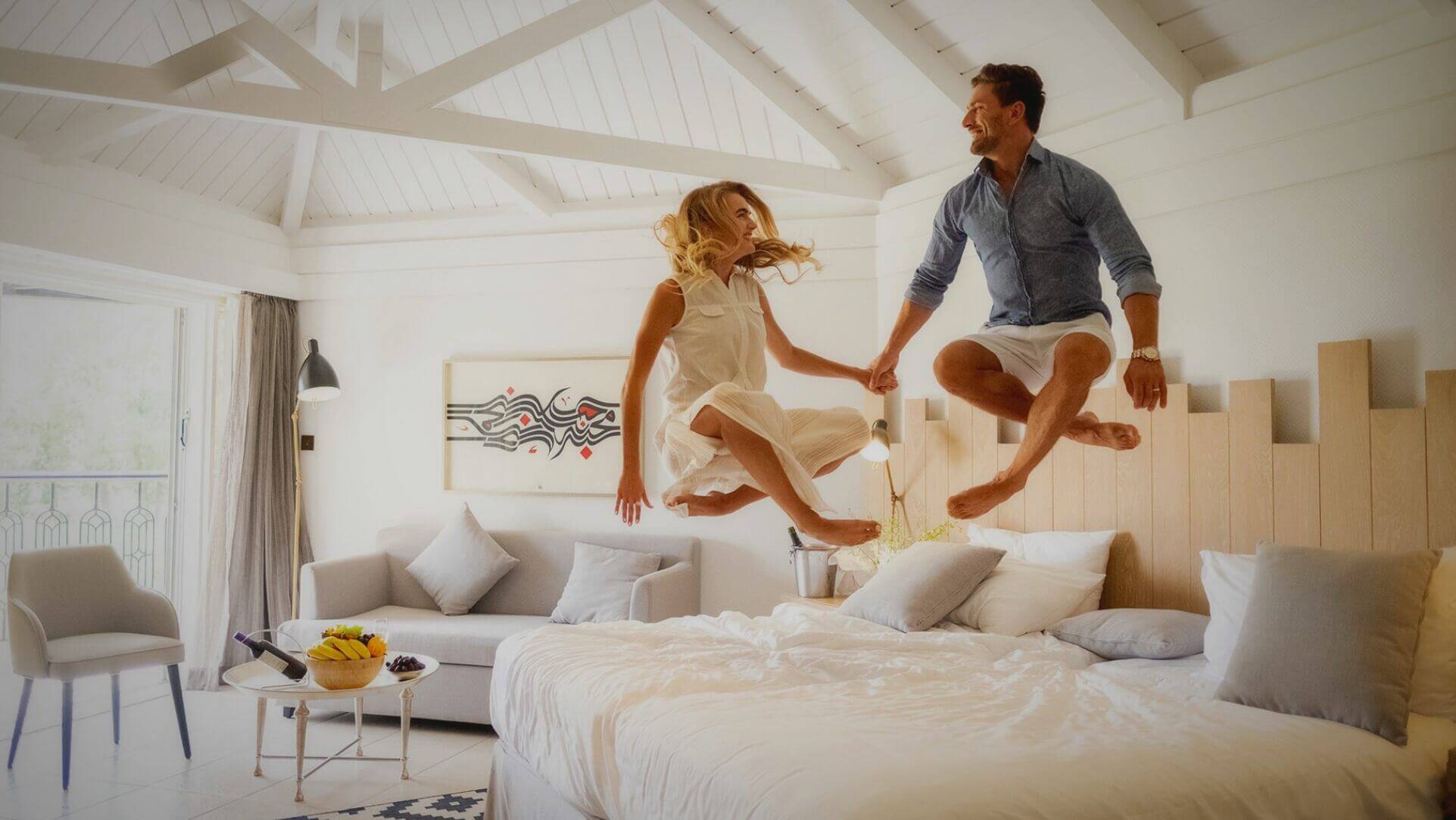 Couple Jumping on King Bed