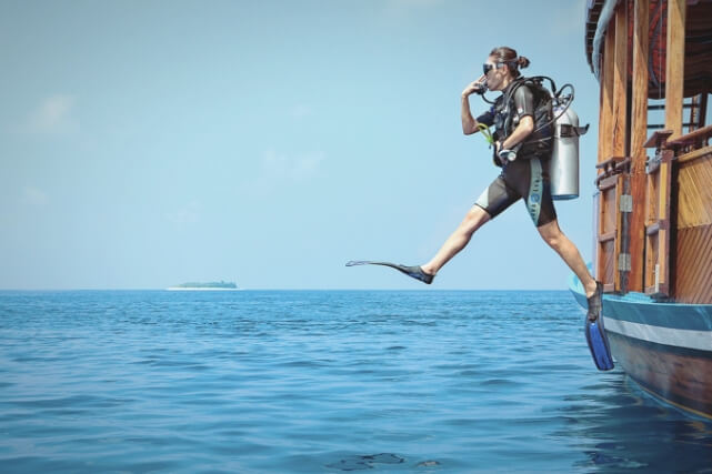 Women Jumping off Boat with Snorkeling Gear