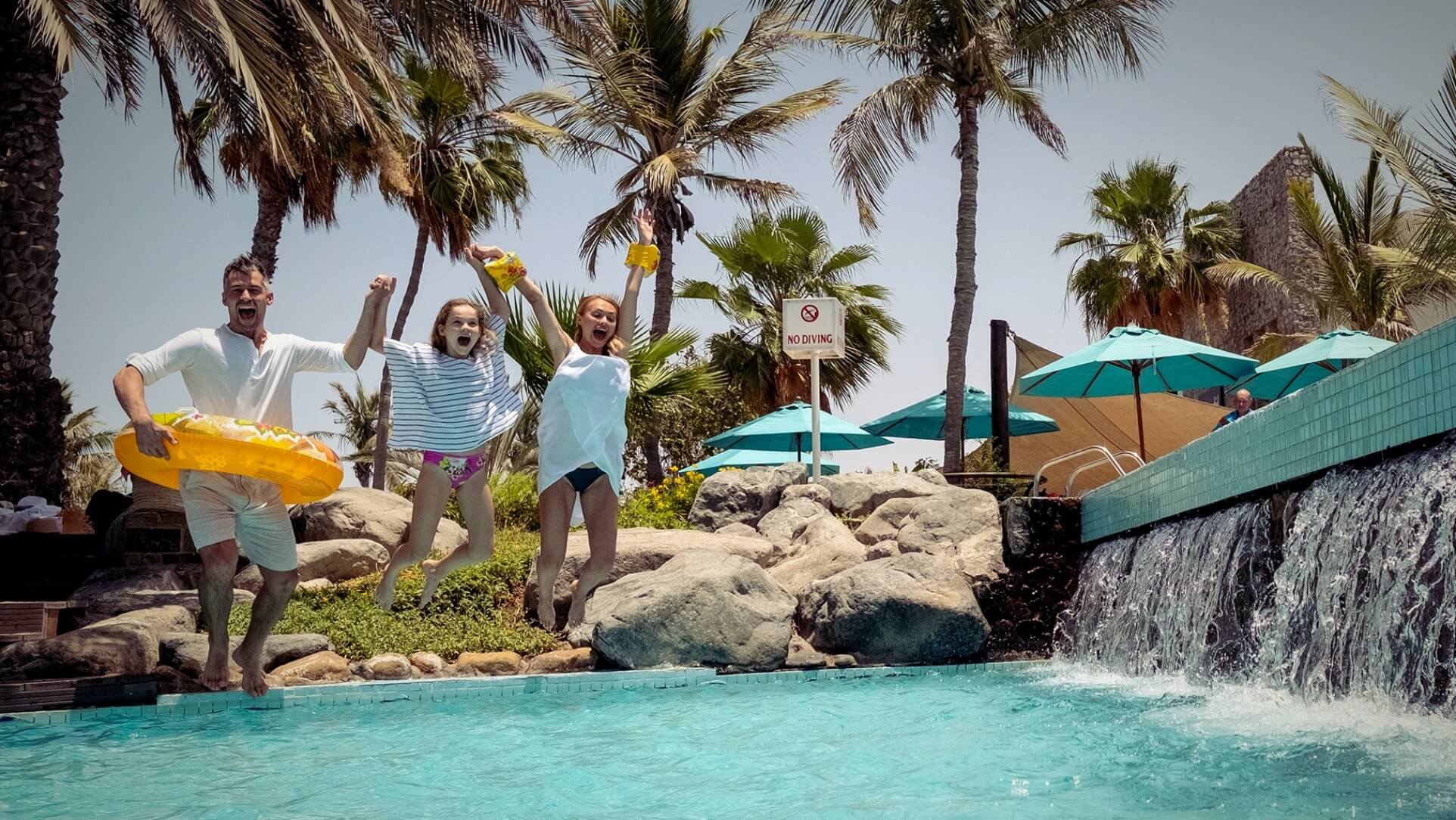 Family Jumping In Pool