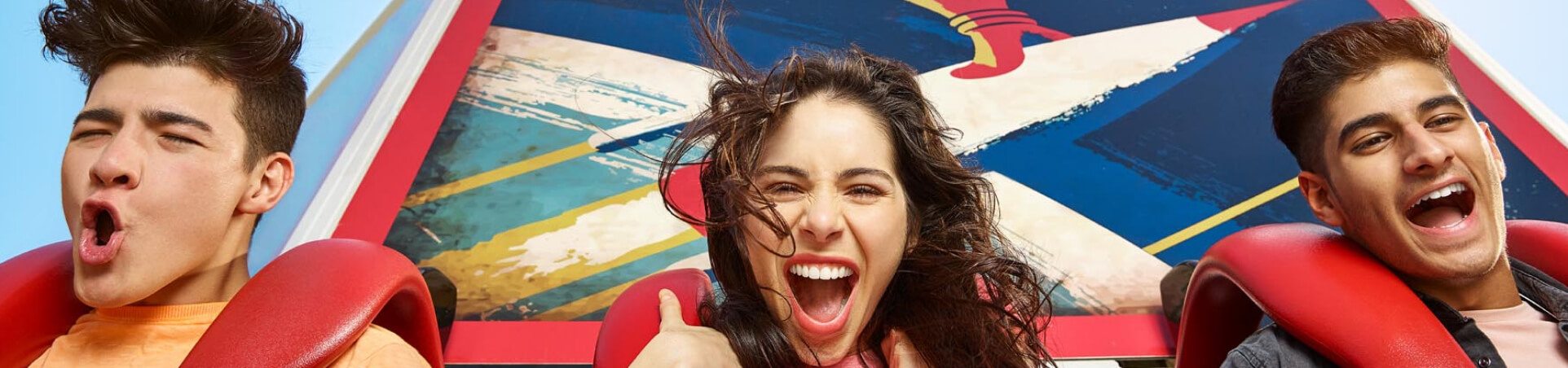 أصدقاء يصرخون من السعادة في قطار ملاهي