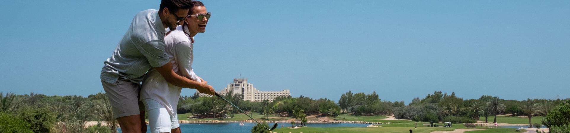 Couple Swinging Golf Club