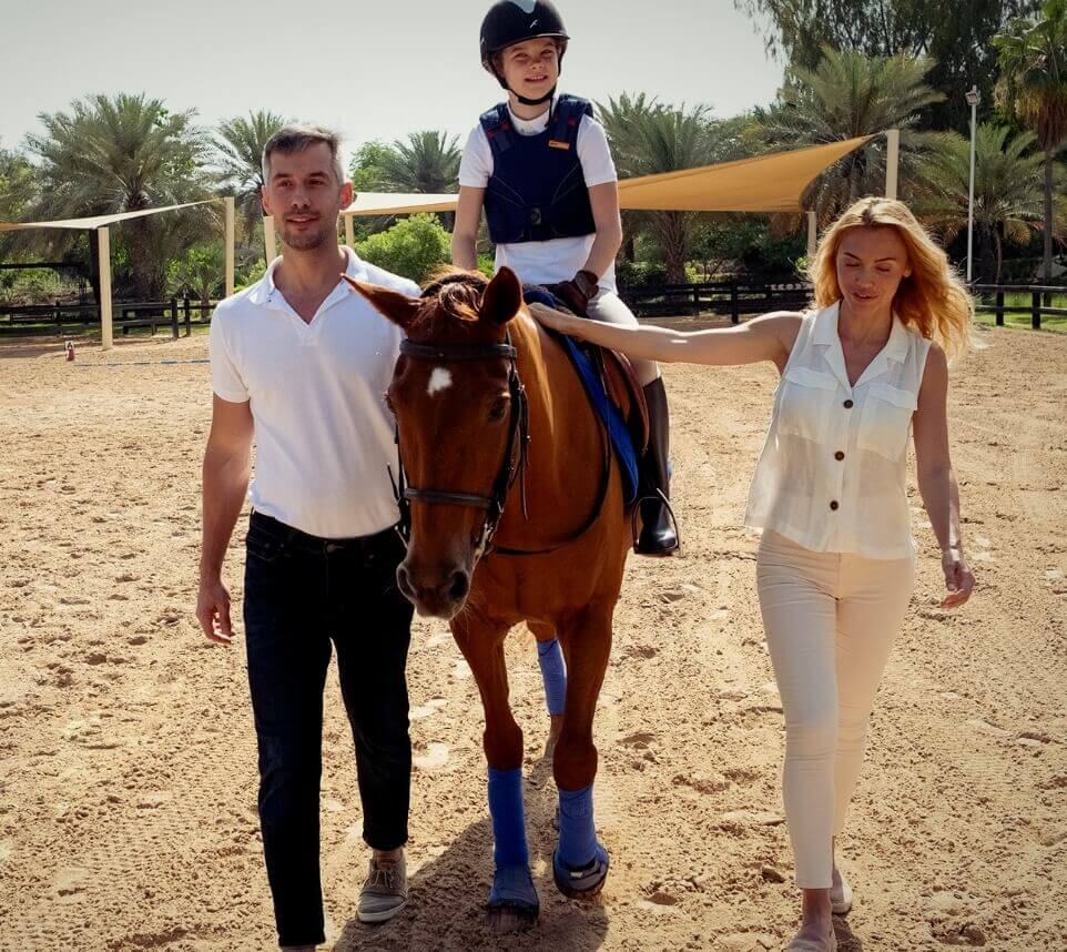 عائلة تسير إلى جوار حصان