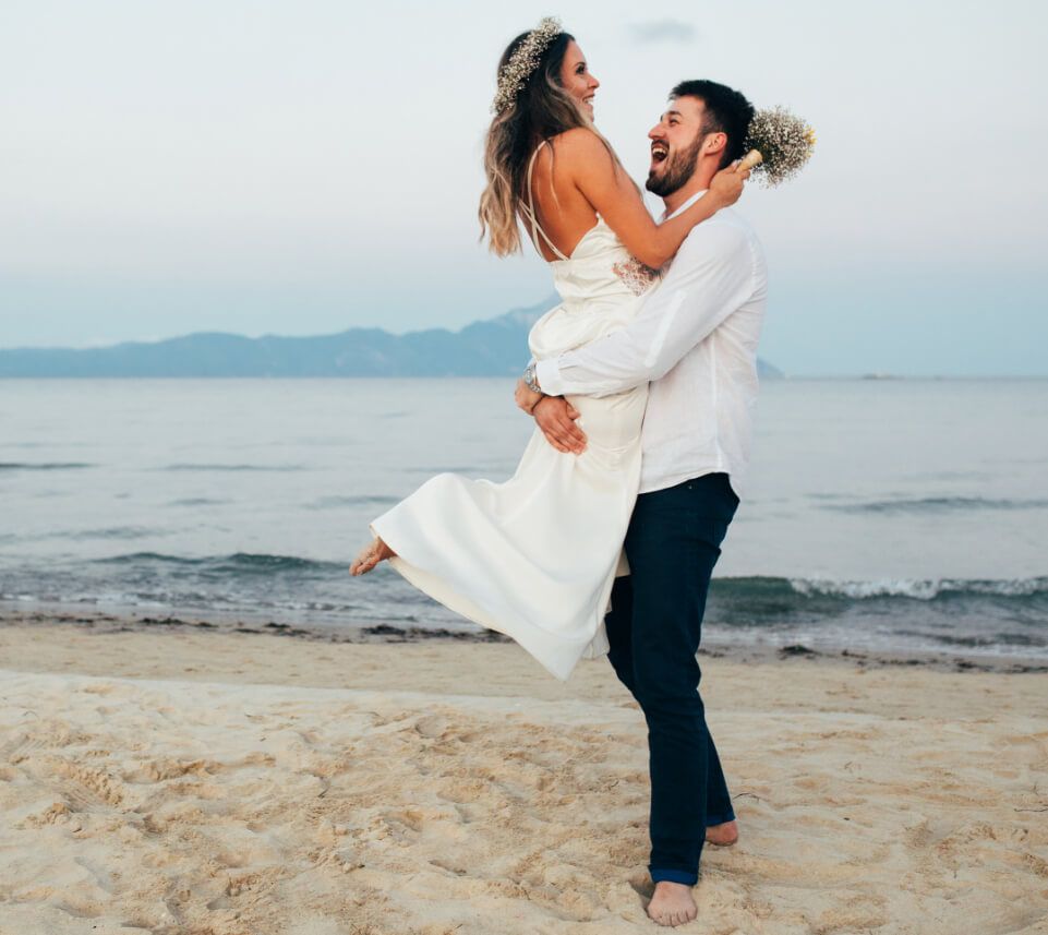 عريس يحمل عروسه على الشاطئ
